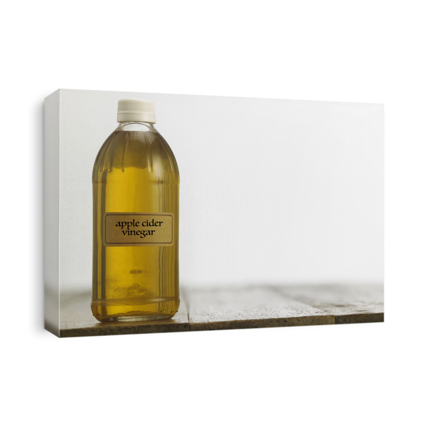 Bottle of clear filtered Apple Cider Vinegar on white background.
